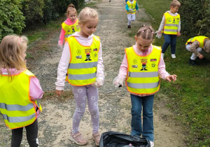 Dzieci sprzątają teren w pobliżu przedszkola