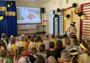 Dzieci oglądają prezentację multimedialną ,,Skąd się bierze miód?"