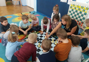 Pionki na szachownicy -ruch pionków i ich wartość (wojna pionków) - dzieci ruszają się pionkami