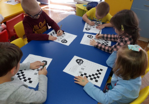Dzieci kolorują pola na szachownicy