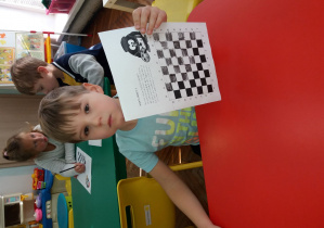 Chłopczyk koloruje pola na szachownicy