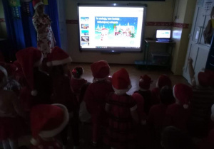 Dzieci oglądają prezentację o Mikołaju