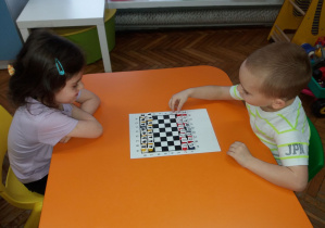 Dzieci grają w własnoręcznie zrobione szachy