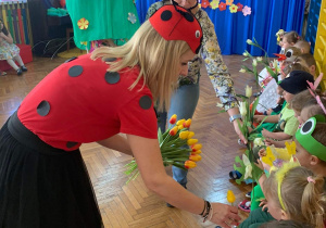 Nauczycielka rozdaje przedszkolakom tulipany
