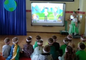 Dzieci oglądają prezentację " Jak dbać o naszą planetę"