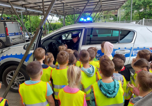 Dzieci oglądają radiowozy policyjne.