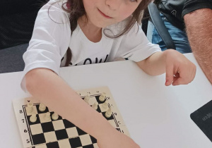 Dziewczynka gra w otrzymane szachy.