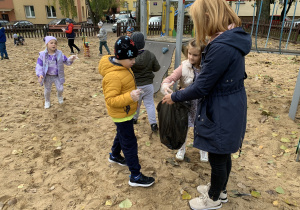 Dzieci sprzątają tereny w pobliżu przedszkola