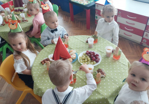 Dzieci jedzą poczęstunek.