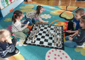 Dzieci grają w zrobione przez siebie szachy.