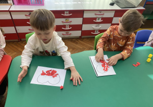 Dzieci wykonują biało- czerwone serca