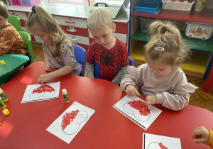 Dzieci wykonują biało- czerwone serca