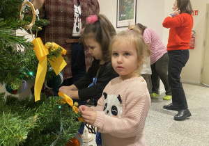 Dzieci dekorują choinkę