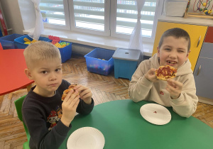 Dzieci jedzą pizzę
