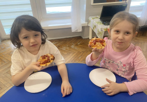 Dzieci jedzą pizzę