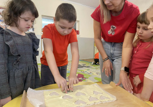 Dzieci przygotowują ciasteczka- serduszka