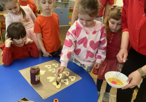 Dzieci przygotowują ciasteczka- serduszka