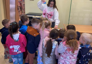Pani Bibliotekarka pokazuje dzieciom kartę czytelnika
