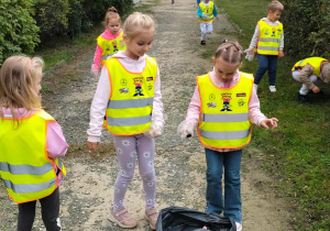 Dzieci sprzątają teren w pobliżu przedszkola