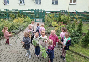 Dzieci robią porządki w ogrodzie i sadzą kwiaty