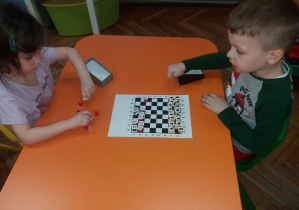 Dzieci grają w własnoręcznie wykonane szachy
