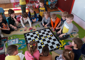 Dzieci zaznaczają ruchy wieży na szachownicy